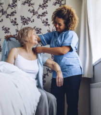 caregiver assisting patient in dressing up