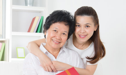 caregiver hugging an old woman