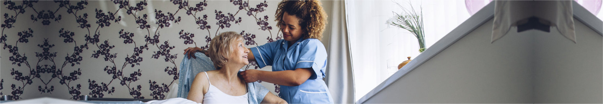 caregiver assisting patient in dressing up